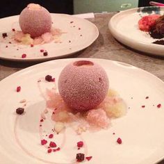 three white plates topped with desserts on top of a table