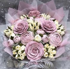 a bouquet of pink and white flowers in a clear vase