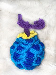 there is a crocheted blue and yellow ball on the fur