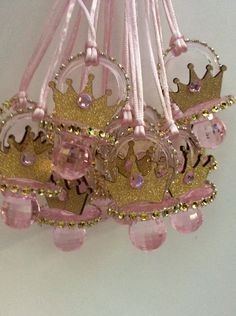 pink and gold tiara ornament hanging on white wall with beads around it