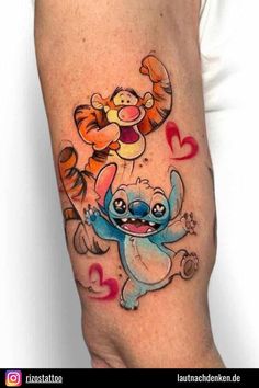 a cartoon tattoo on the arm of a person with an elephant and tigger character