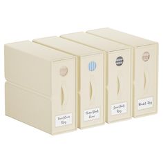 three white boxes with labels on them sitting side by side in front of each other