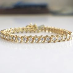 This diamond s link tennis bracelet is a classic staple for any jewelry collection! The diamonds are set in 18k yellow gold and circle the entire bracelet. Metal: 18K Yellow Gold Diamonds: 2.25 CTW SI2-I1 G-H Length: 7.25 For a greater selection of jewelry please visit our website at www.BlackMarketLLC.com If you have any questions about this product or if we can help you with any of our other products please contact us through Etsy or our website at www.BlackMarketLLC.com Each piece of our jewe Fine Jewelry Tennis Bracelet With Round Cut For Anniversary, Fine Jewelry Tennis Bracelet For Anniversary, Classic Round Diamond White Gold Bracelet, Classic Round Gold Bracelet With Diamond Accents, Yellow Gold Tennis Bracelet With Diamond Accents For Anniversary, Yellow Gold Tennis Bracelet With Cubic Zirconia Round Cut, Yellow Gold Cubic Zirconia Tennis Bracelet With Round Cut, Yellow Gold Cubic Zirconia Tennis Bracelet, Gold Bracelet With Brilliant Cut For Anniversary