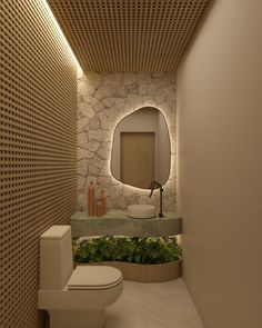 a bathroom with a toilet, sink and mirror in it's center wall is lit by recessed lighting