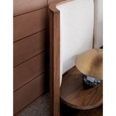 a close up of a wooden table with a white chair and some drawers in the background