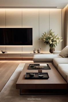 a living room with white couches and a large tv