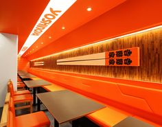 the interior of a restaurant with orange booths