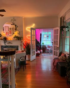 a living room filled with furniture and a fire place next to a window covered in plants