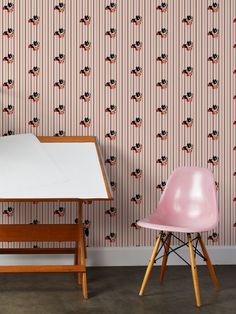 two chairs and a table in front of a wallpapered room with mickey mouses