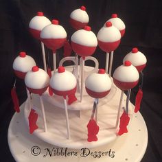 a cake with red and white frosting on top is surrounded by marshmallows