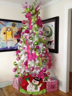 a white christmas tree with pink and green ornaments