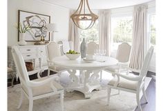 a white dining room table and chairs in front of a window