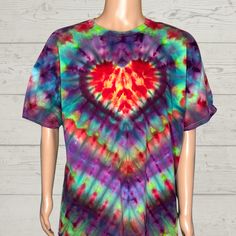 a tie - dyed shirt with a red heart on the front and blue, green, purple, and yellow colors