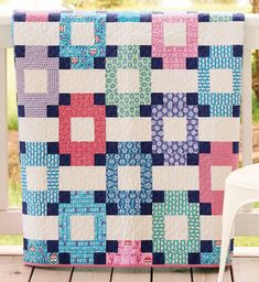 a colorful quilt sitting on top of a wooden deck