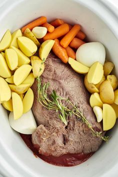 meat, potatoes and carrots in a white crock pot