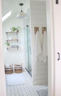 a bathroom with white walls and hexagonal tile flooring in the shower area