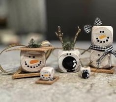 three snowmen made out of toilet paper and decorated with black and white bows, sitting next to each other