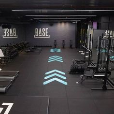 an empty gym with treadmills and exercise equipment in the foreground, blue arrows painted on the floor