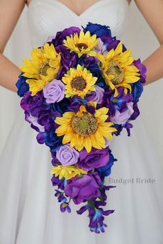 a bride holding a bouquet of sunflowers and purple roses