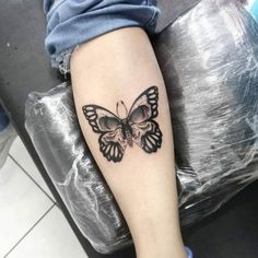 a black and white butterfly tattoo on the leg