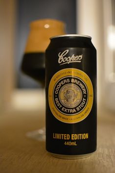 a can of beer sitting on top of a wooden table