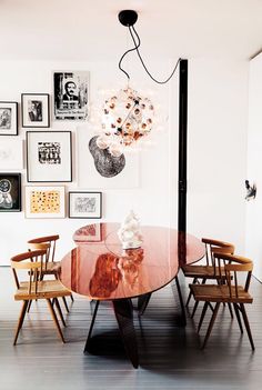 a table with chairs and pictures on the wall behind it, in an instagram