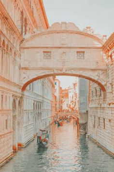 a bridge over a canal with gondolas and buildings on both sides in venice, italy