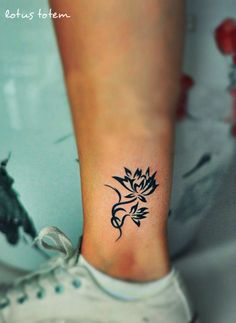 a woman's foot with a small flower tattoo on the left side of her ankle