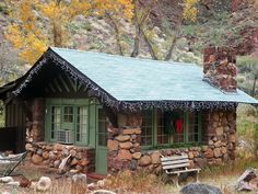 this is an image of a small cabin in the woods with green doors and windows