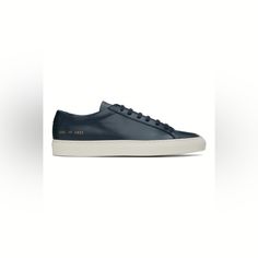 Low-Top Buffed Leather Sneakers In Navy. Signature Series Stamp At Outer Side. Lace-Up Closure Padded Tongue And Collar Suede And Buffed Leather Lining Treaded Rubber Sole Modern Navy Sneakers With Round Toe, Sporty Navy Sneakers With Leather Sole, Classic Blue Sneakers With Vulcanized Sole, Navy Sneakers With Leather Sole And Round Toe, Classic Navy Sneakers With Contrast Sole, Classic Navy Sneakers With Textured Sole, Classic Blue Sneakers With Textured Sole, Classic Navy Sneakers With Leather Sole, Classic Navy High-top Sneakers