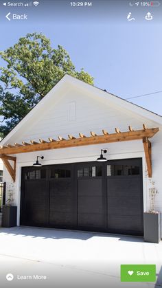 a white house with two black garage doors