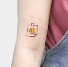 a small smiley face tattoo on the arm