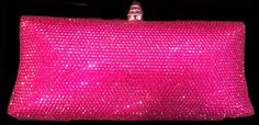 pink sequin clutch bag on black background