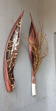 two giraffe heads mounted to the side of a wall next to each other