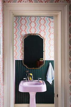 a bathroom sink sitting under a mirror next to a wall mounted faucet in front of a doorway