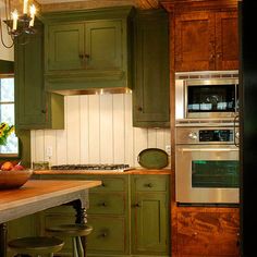 a kitchen with green cabinets and an oven