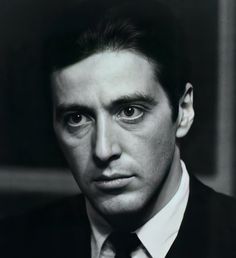 a black and white photo of a man in a suit with a serious look on his face