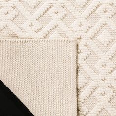 the black and white rug is laying on top of the bed coverlet, which has been folded over