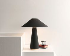 a black lamp sitting on top of a white shelf