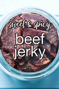 a glass jar filled with beet and spicy beef jelks on top of a blue table