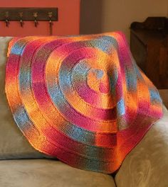 a crocheted blanket sitting on top of a couch