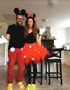 a man and woman in mickey mouse costumes