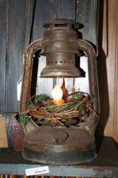 an old fashioned bell sitting on top of a table next to a bird's nest