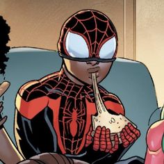 a spider - man eating pizza while sitting on a couch in front of a woman