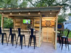 a man standing in front of a bar with lots of stools and chairs around it