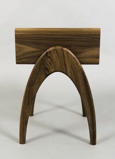 a wooden table with an arch shaped like a book stand on it's side