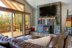 a living room filled with furniture and a flat screen tv mounted on the wall above a fire place