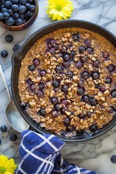 blueberry baked oatmeal in a pan with fresh blueberries