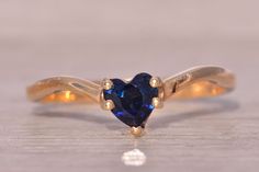 a blue heart shaped ring with gold accents