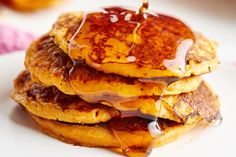 a stack of pancakes with syrup being drizzled on top